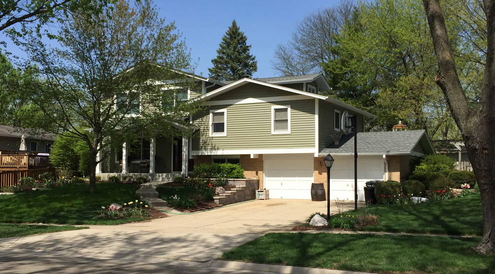 Mid-sized transitional split-level green house exterior in Chicago with concrete fiberboard siding, a gable roof, a shingle roof, a grey roof and board and batten siding.