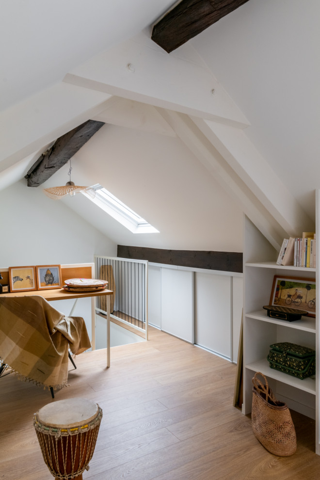 Photo of a medium sized mediterranean study in Paris with white walls, light hardwood flooring, a built-in desk and exposed beams.