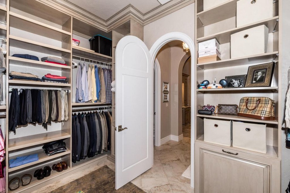 Large mediterranean gender-neutral dressing room in Other with raised-panel cabinets and beige cabinets.