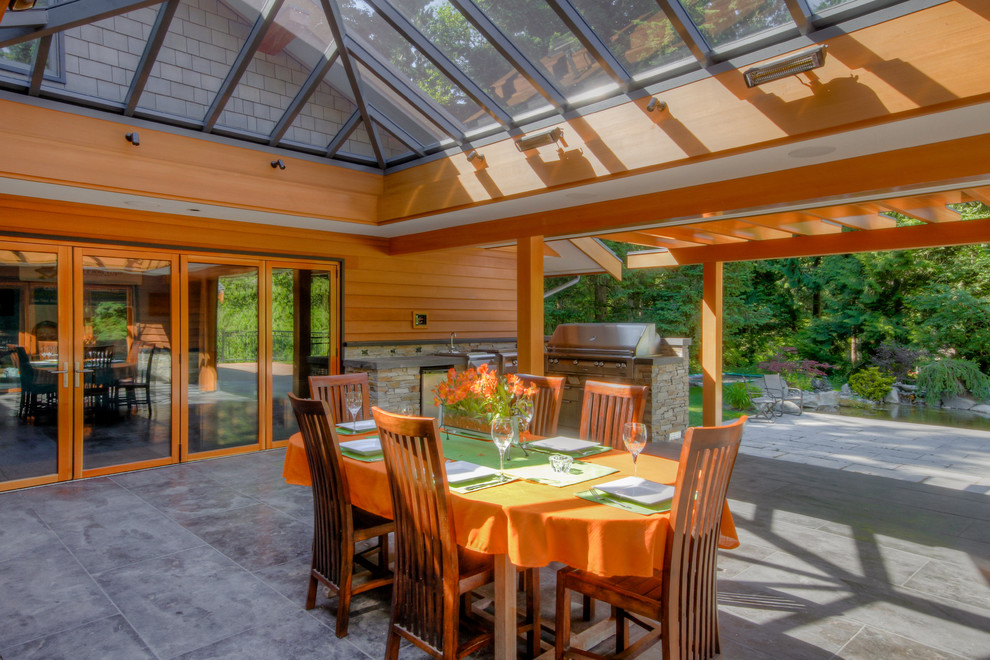 This is an example of a contemporary patio in Vancouver with a roof extension.