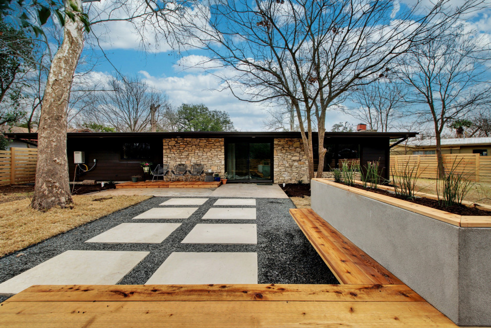 Mittelgroßer Retro Garten hinter dem Haus mit Wüstengarten, direkter Sonneneinstrahlung, Betonboden und Holzzaun in Austin