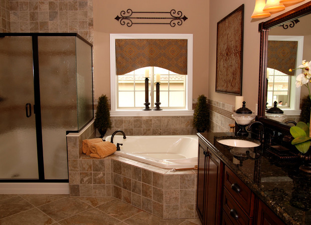 Inspiration for a small traditional master bathroom in New York with raised-panel cabinets, dark wood cabinets, a corner tub, a corner shower, a one-piece toilet, black tile, pink walls, travertine floors, an undermount sink and engineered quartz benchtops.