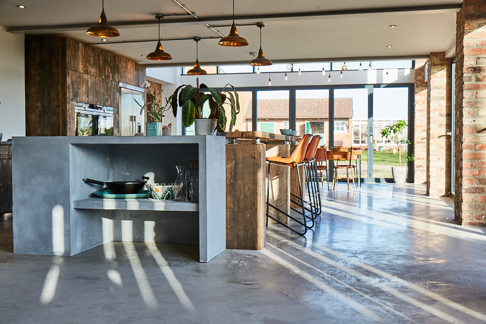 Design ideas for a large industrial open plan kitchen in Other with an undermount sink, flat-panel cabinets, medium wood cabinets, zinc benchtops, grey splashback, stainless steel appliances, concrete floors, a peninsula, grey floor and grey benchtop.