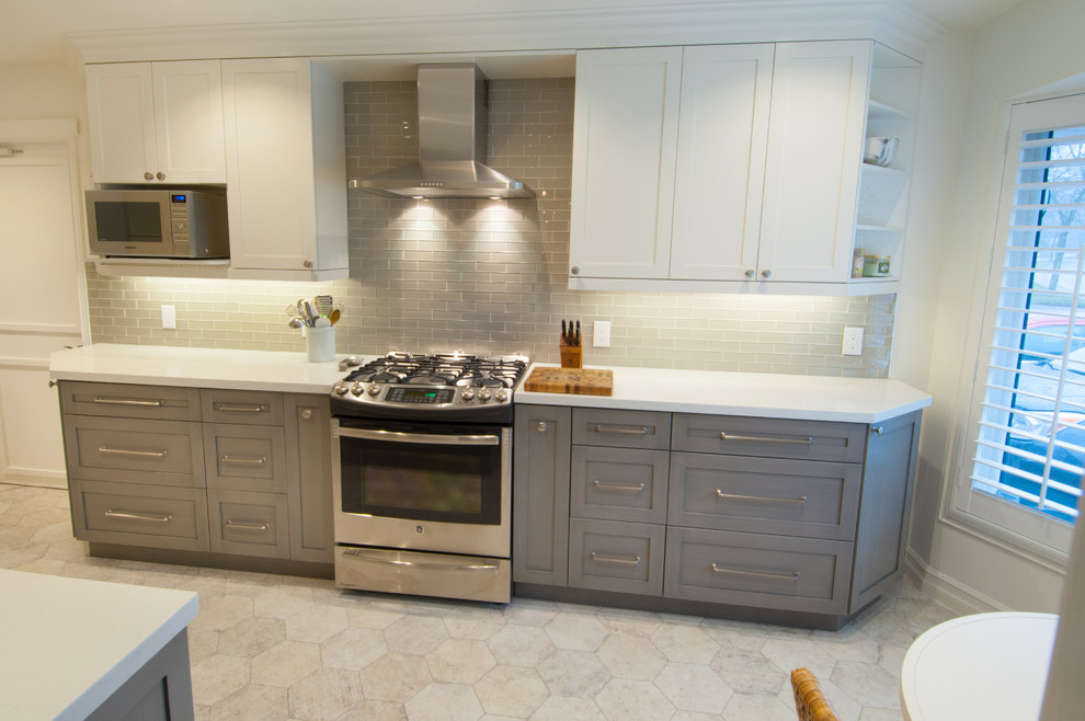 Example of a mid-sized transitional galley ceramic tile enclosed kitchen design in Toronto with shaker cabinets, white cabinets, quartzite countertops, gray backsplash, glass tile backsplash, stainless steel appliances and no island