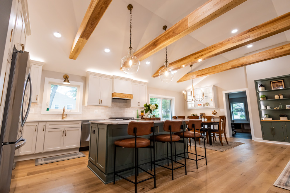 Inspiration for a large transitional l-shaped light wood floor, brown floor and exposed beam eat-in kitchen remodel in DC Metro with an undermount sink, shaker cabinets, quartz countertops, white backsplash, porcelain backsplash, stainless steel appliances, an island and white countertops