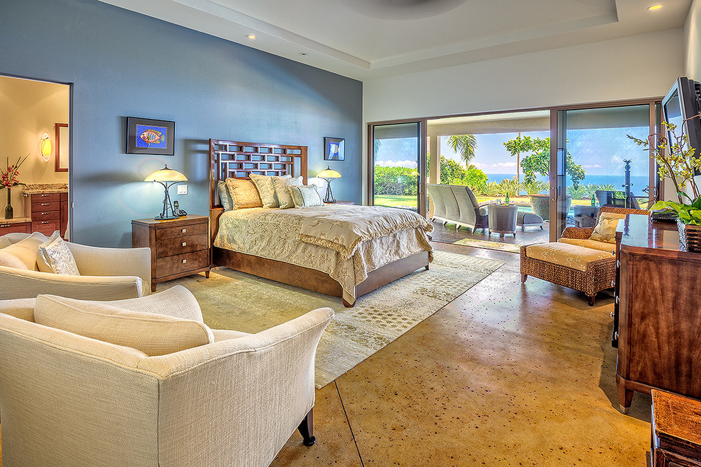 This is an example of an expansive contemporary master bedroom in Hawaii with blue walls, concrete floors, no fireplace and beige floor.