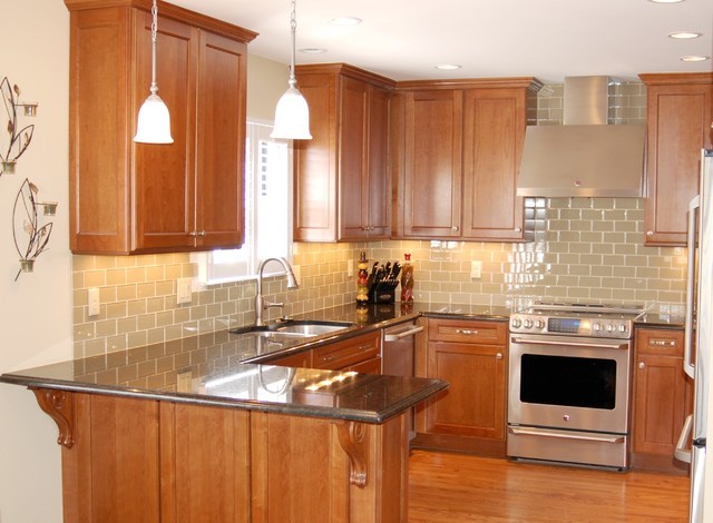 Example of a mid-sized transitional u-shaped medium tone wood floor eat-in kitchen design with an undermount sink, recessed-panel cabinets, medium tone wood cabinets, granite countertops, green backsplash, subway tile backsplash, stainless steel appliances and a peninsula