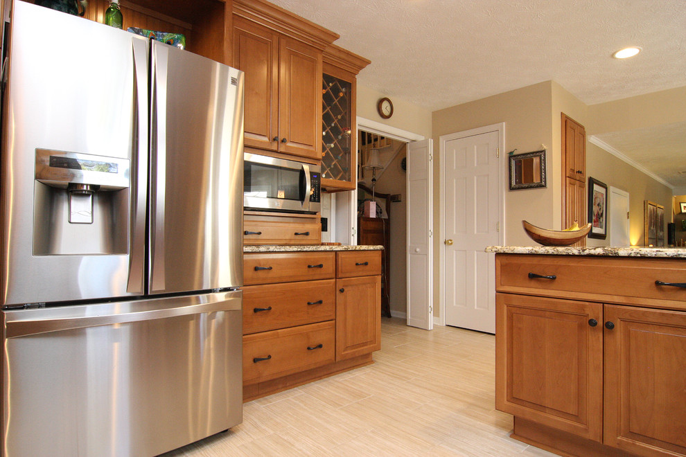 Example of a large transitional u-shaped porcelain tile eat-in kitchen design with an undermount sink, raised-panel cabinets, medium tone wood cabinets, granite countertops, beige backsplash, porcelain backsplash and stainless steel appliances