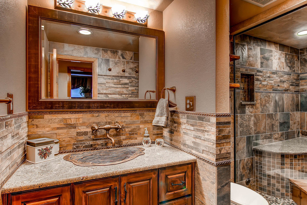 Large country master bathroom in Denver with a drop-in sink, raised-panel cabinets, medium wood cabinets, granite benchtops, a double shower, a two-piece toilet, beige tile, ceramic tile, brown walls and ceramic floors.