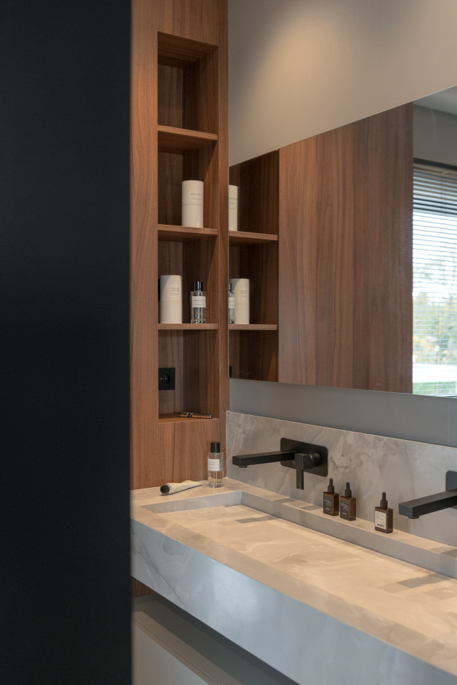Design ideas for a mid-sized contemporary master bathroom in Lyon with dark wood cabinets, a freestanding tub, a curbless shower, gray tile, ceramic tile, grey walls, ceramic floors, a trough sink, onyx benchtops, grey floor, grey benchtops, a niche, a single vanity and a built-in vanity.