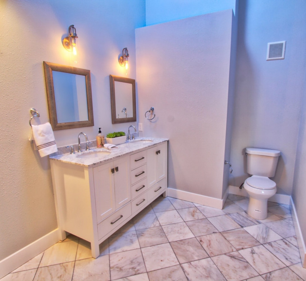 Cette photo montre une salle de bain principale chic de taille moyenne avec un placard à porte shaker, des portes de placard blanches, une baignoire d'angle, un combiné douche/baignoire, un mur multicolore, un sol en carrelage de céramique, un lavabo encastré, un plan de toilette en granite, un sol blanc, aucune cabine, meuble double vasque et meuble-lavabo encastré.