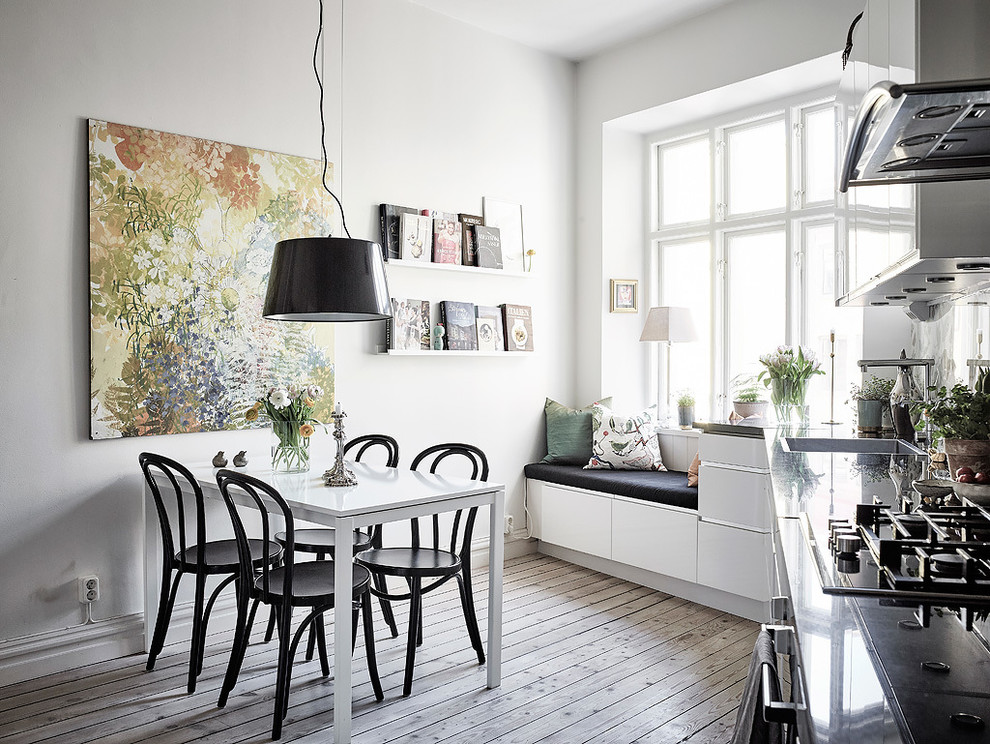 This is an example of a large scandinavian kitchen/dining combo in Gothenburg with white walls, light hardwood floors and no fireplace.
