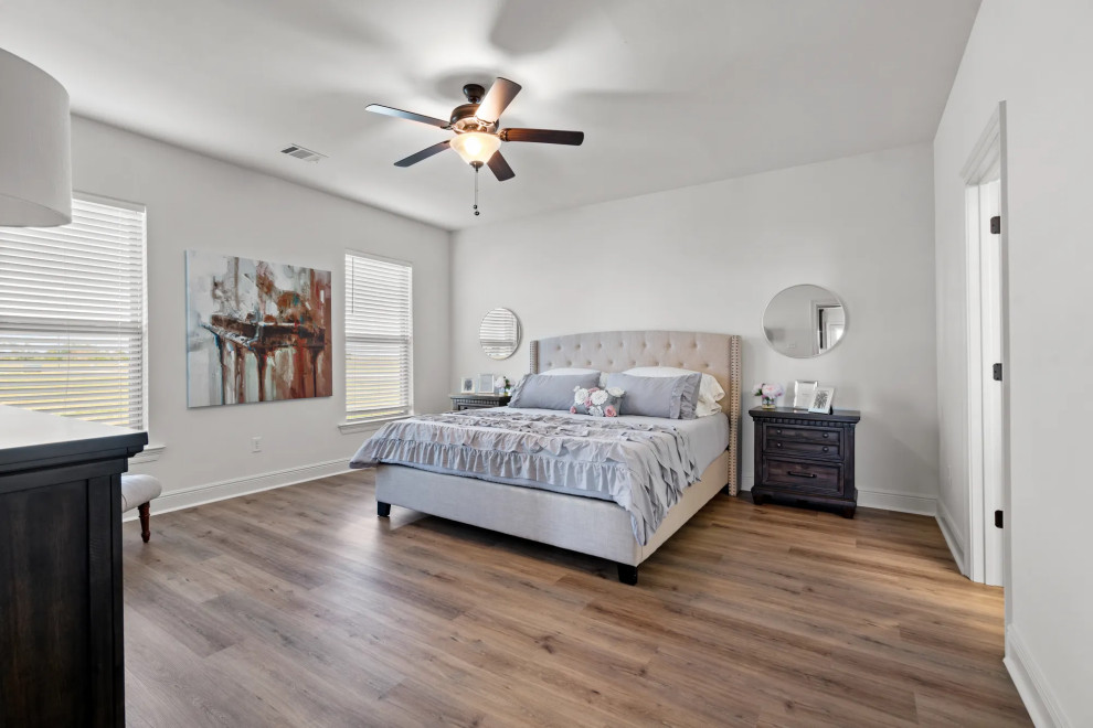 Diseño de dormitorio principal clásico de tamaño medio con paredes blancas, suelo vinílico y suelo marrón
