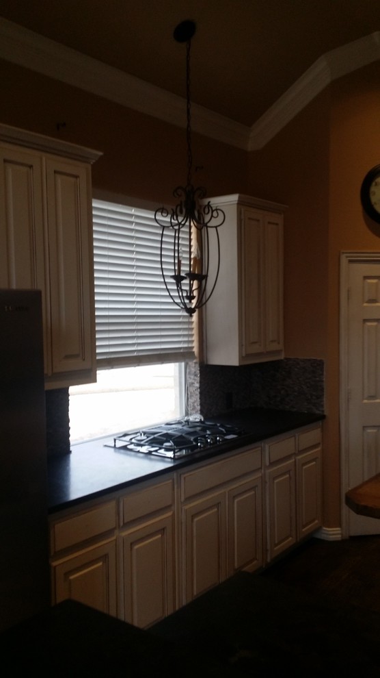 Example of a large transitional brown floor open concept kitchen design in Dallas with an undermount sink, raised-panel cabinets, white cabinets, granite countertops, gray backsplash, stone tile backsplash, stainless steel appliances and an island