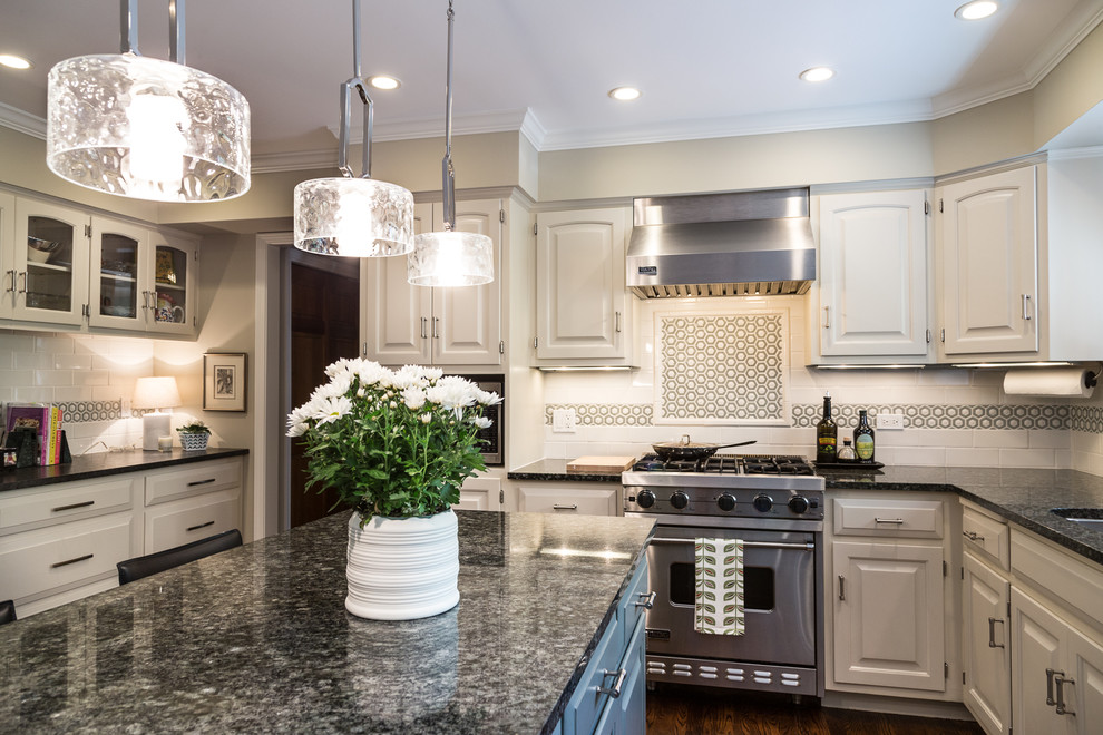 Large transitional u-shaped brown floor and dark wood floor eat-in kitchen photo in Chicago with an undermount sink, raised-panel cabinets, white cabinets, granite countertops, white backsplash, stainless steel appliances, an island and subway tile backsplash