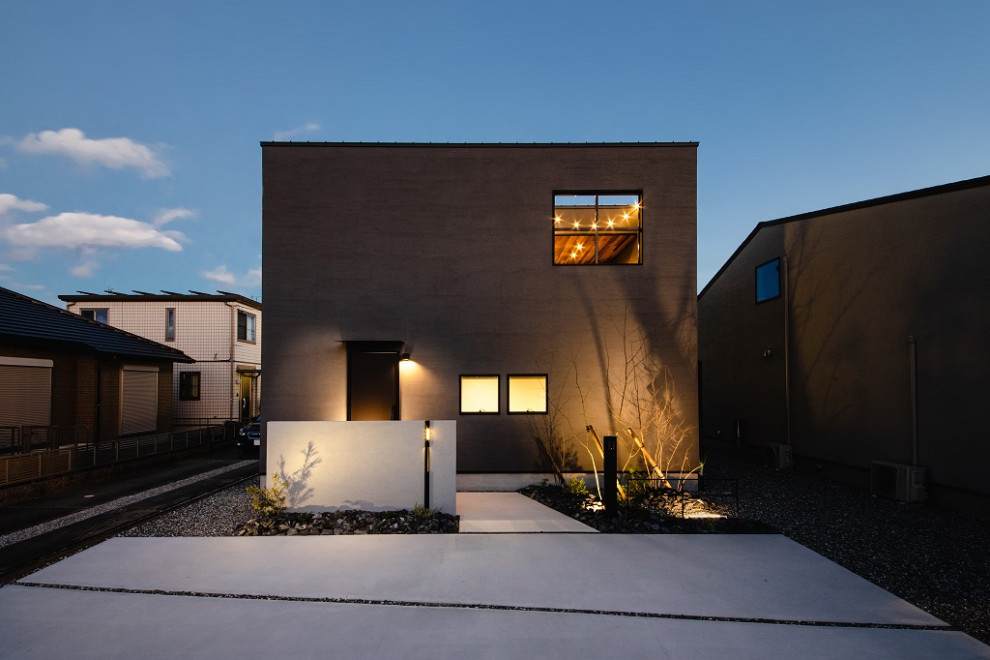 Idées déco pour une façade de maison grise contemporaine avec un toit plat.