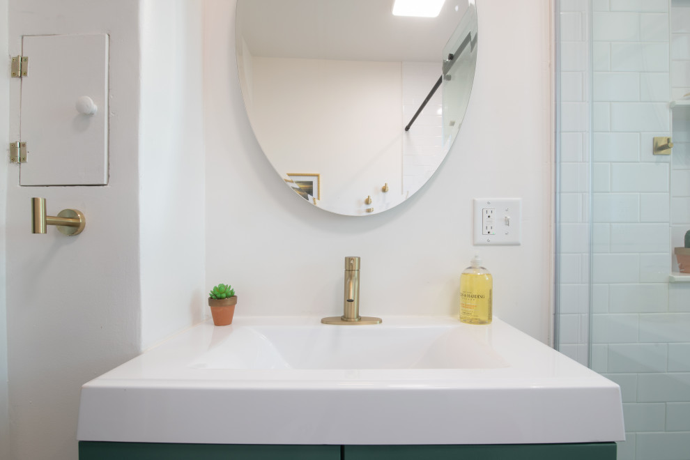 Стильный дизайн: ванная комната среднего размера в стиле шебби-шик с фасадами в стиле шейкер, зелеными фасадами, раздельным унитазом, белой плиткой, керамогранитной плиткой, белыми стенами, полом из керамогранита, душевой кабиной, монолитной раковиной, столешницей из искусственного камня, белым полом, душем с раздвижными дверями, белой столешницей, нишей, тумбой под одну раковину и напольной тумбой - последний тренд