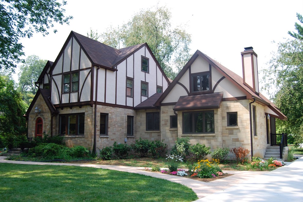 This is an example of a large traditional two-storey beige house exterior in Louisville with mixed siding, a gable roof and a shingle roof.