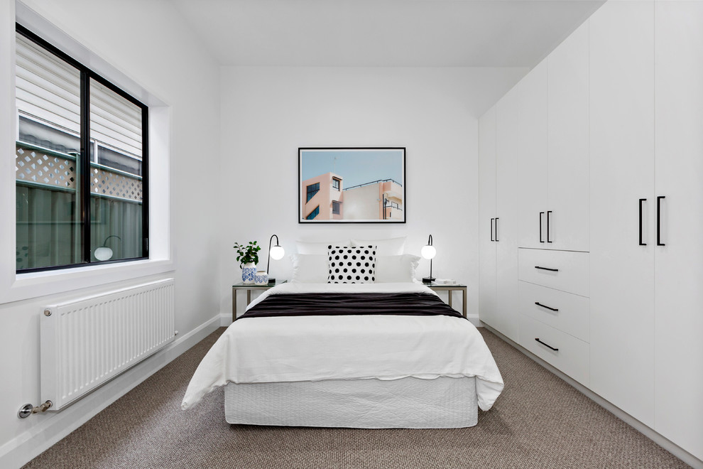 This is an example of a contemporary guest bedroom in Melbourne with white walls, carpet and brown floor.