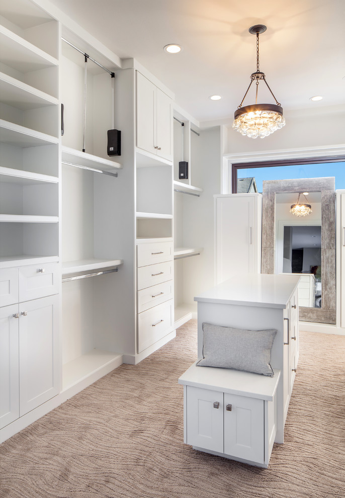 Large country gender-neutral walk-in wardrobe in Portland with shaker cabinets, white cabinets, carpet and beige floor.