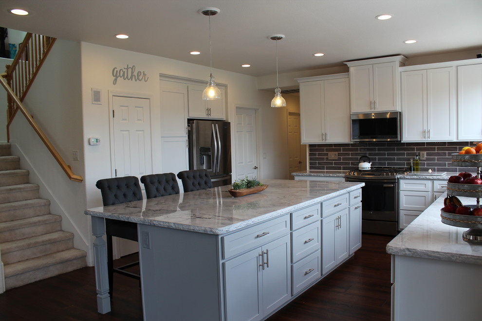 Inspiration for a mid-sized transitional l-shaped medium tone wood floor and brown floor open concept kitchen remodel with an undermount sink, marble countertops, gray backsplash, ceramic backsplash, stainless steel appliances and an island