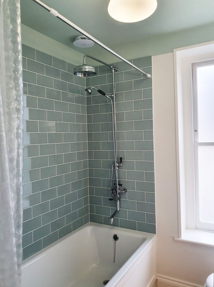 Modelo de cuarto de baño único y de pie contemporáneo con armarios estilo shaker, bañera encastrada, baldosas y/o azulejos azules, paredes blancas, suelo de bambú y lavabo encastrado