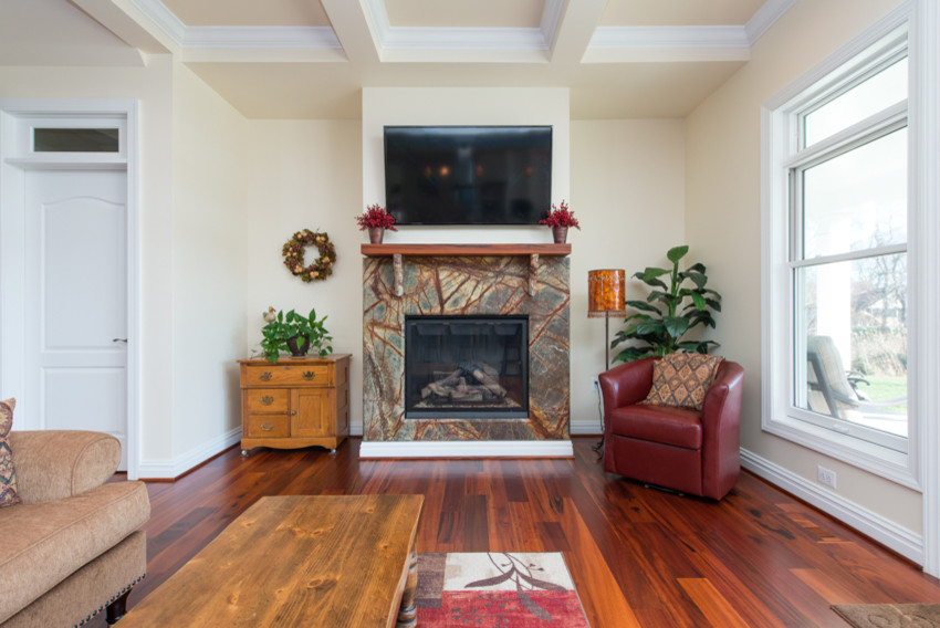 This is an example of a small contemporary open concept living room in Baltimore with beige walls, medium hardwood floors, a standard fireplace, a stone fireplace surround and a wall-mounted tv.