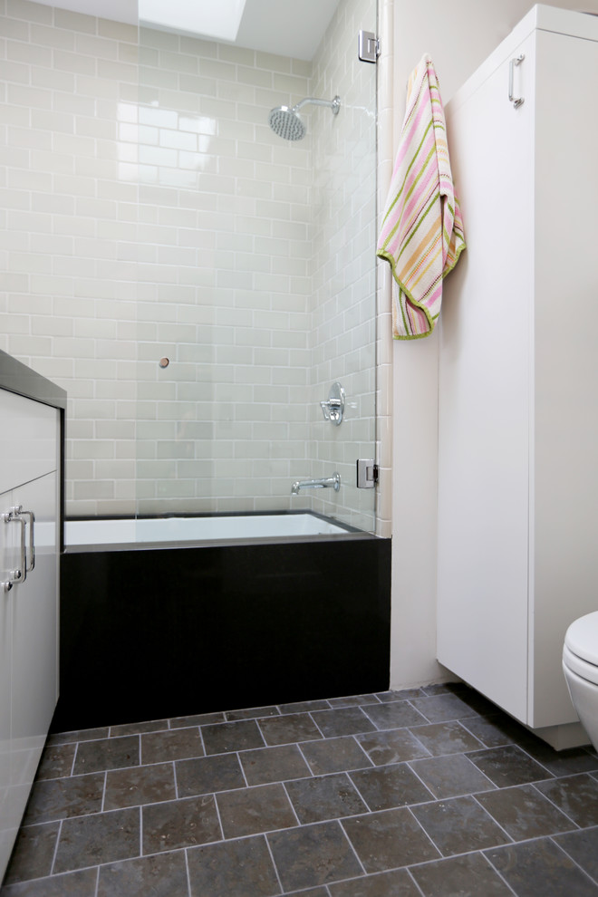 Mid-sized industrial 3/4 bathroom in San Diego with flat-panel cabinets, grey cabinets, marble benchtops, beige tile, ceramic tile, an undermount tub, a corner shower, a two-piece toilet, an undermount sink, white walls and limestone floors.