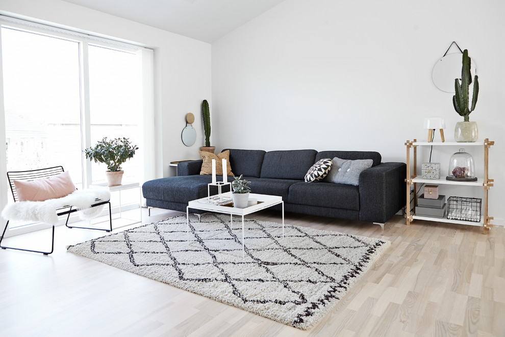 Design ideas for a mid-sized scandinavian formal open concept living room in Wiltshire with white walls, light hardwood floors, no fireplace and no tv.