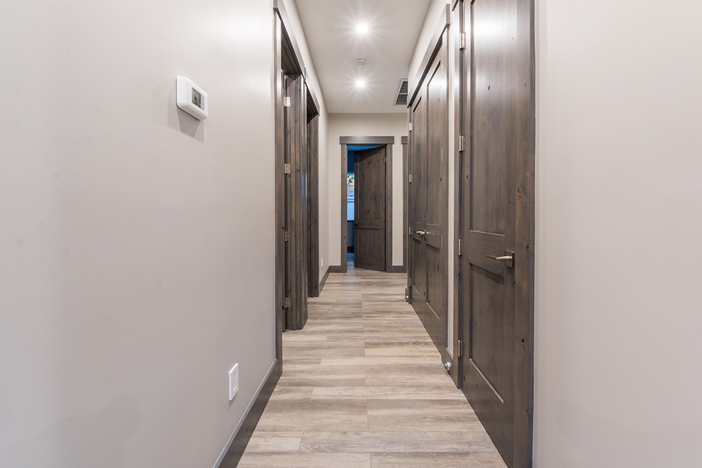 Mid-sized contemporary hallway in San Diego with grey walls, laminate floors and brown floor.