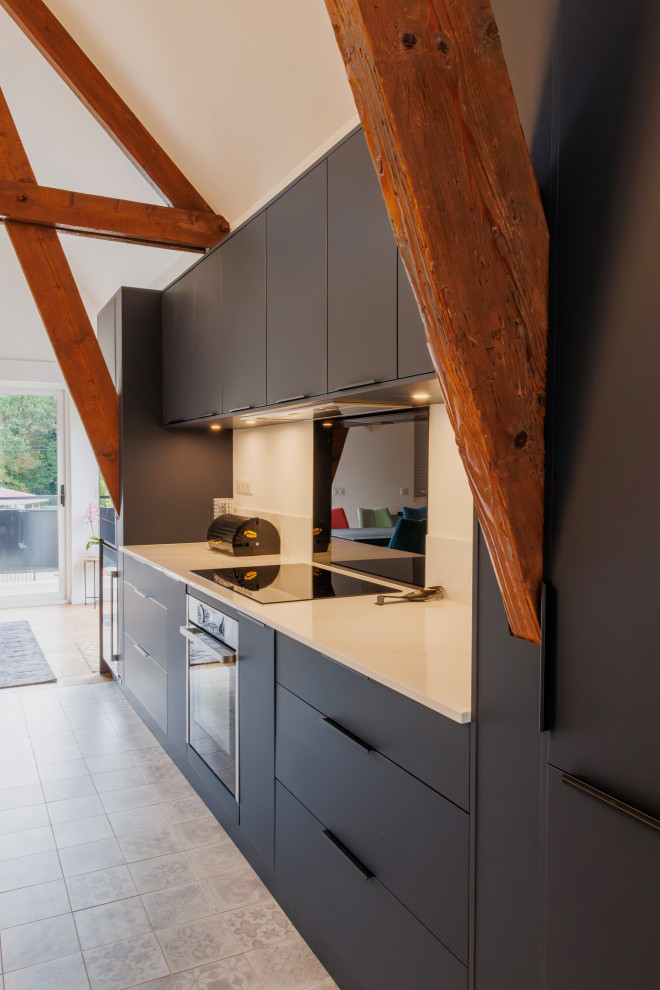 Mid-sized arts and crafts galley open plan kitchen in Paris with an integrated sink, flat-panel cabinets, blue cabinets, quartzite benchtops, white splashback, engineered quartz splashback, stainless steel appliances, cement tiles, with island, white benchtop and exposed beam.