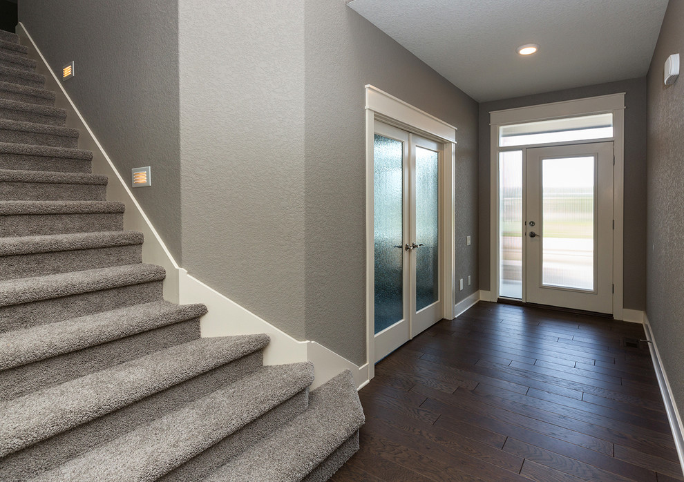 Transitional dark wood floor front door photo with gray walls and a glass front door