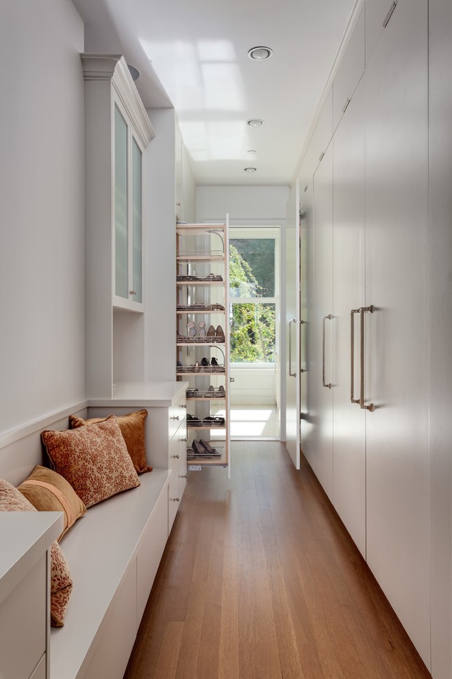 Transitional medium tone wood floor closet photo in New York with flat-panel cabinets and white cabinets