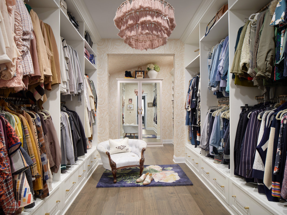 Example of a mid-sized transitional gender-neutral dark wood floor and brown floor walk-in closet design in Denver with glass-front cabinets