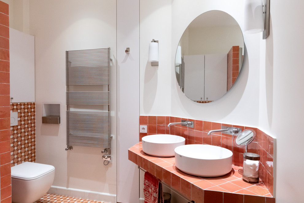 Design ideas for a mid-sized contemporary master bathroom in Paris with beaded inset cabinets, white cabinets, pink tile, terra-cotta tile, white walls, cement tiles, a console sink, tile benchtops, pink floor and pink benchtops.