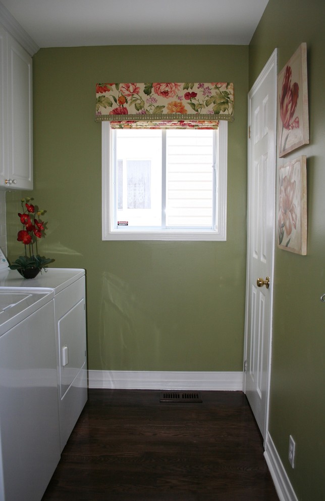 Photo of a small traditional single-wall dedicated laundry room in Ottawa with a single-bowl sink, raised-panel cabinets, white cabinets, laminate benchtops, white splashback, subway tile splashback, green walls, dark hardwood floors, a side-by-side washer and dryer, brown floor and white benchtop.