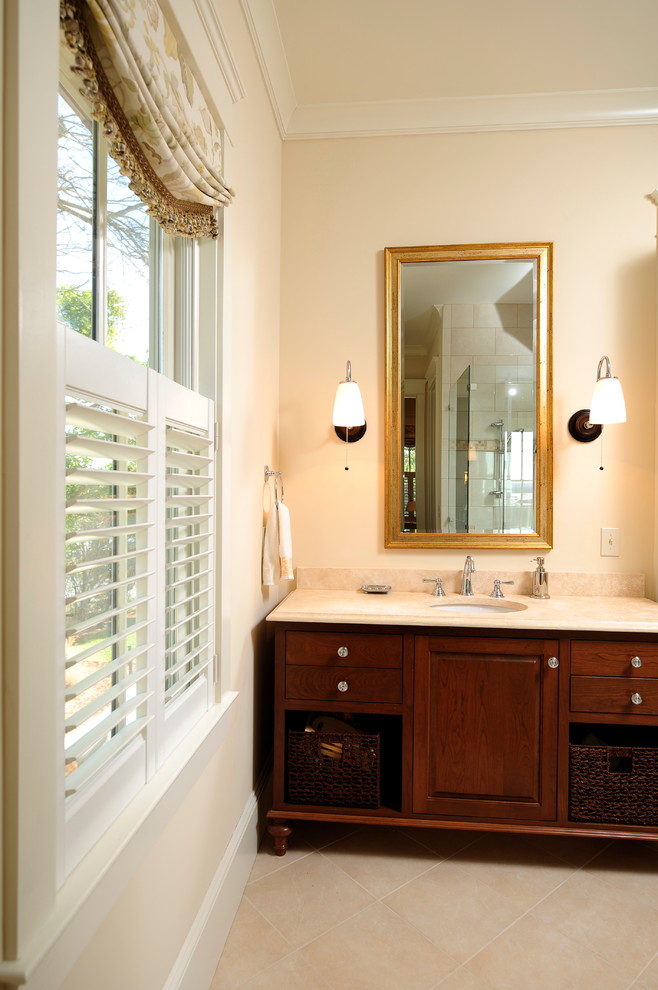 Inspiration for a mid-sized traditional bathroom in Charleston with raised-panel cabinets, dark wood cabinets, beige walls, ceramic floors, an undermount sink, granite benchtops and beige floor.