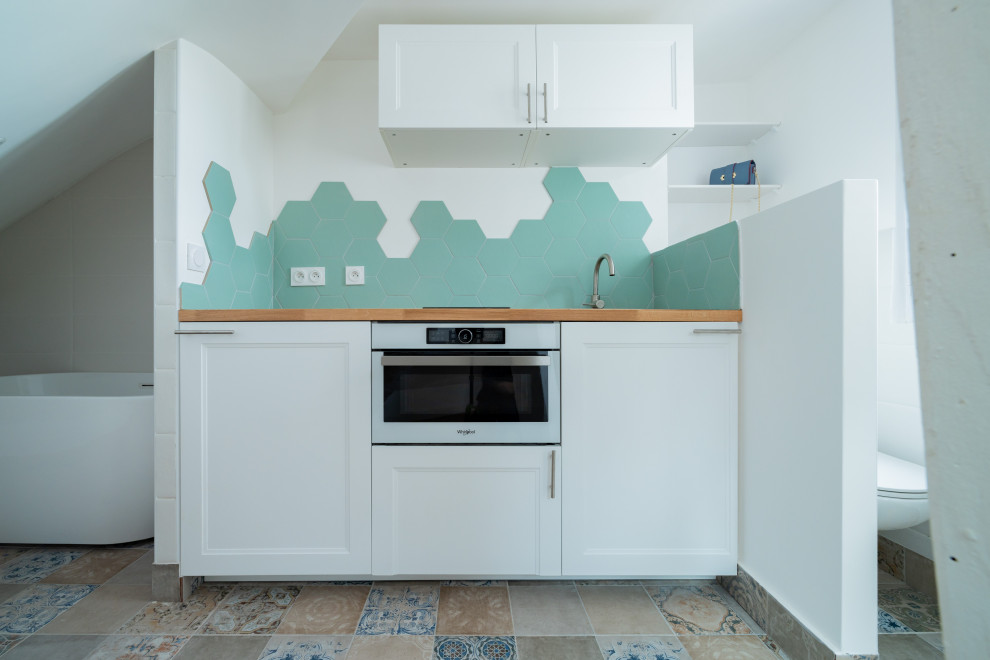 Idéer för att renovera ett litet nordiskt brun linjärt brunt kök med öppen planlösning, med en undermonterad diskho, träbänkskiva, grönt stänkskydd, stänkskydd i keramik, vita vitvaror, cementgolv och blått golv