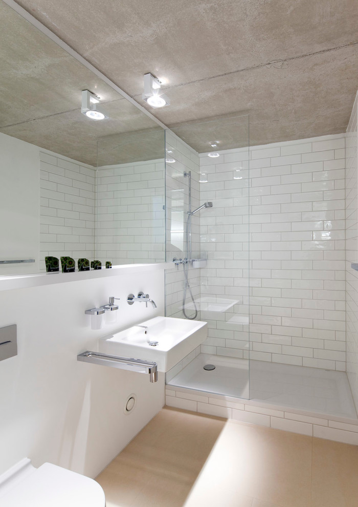 Mid-sized contemporary 3/4 bathroom in Munich with an alcove shower, a wall-mount toilet, white tile, subway tile, white walls and a wall-mount sink.