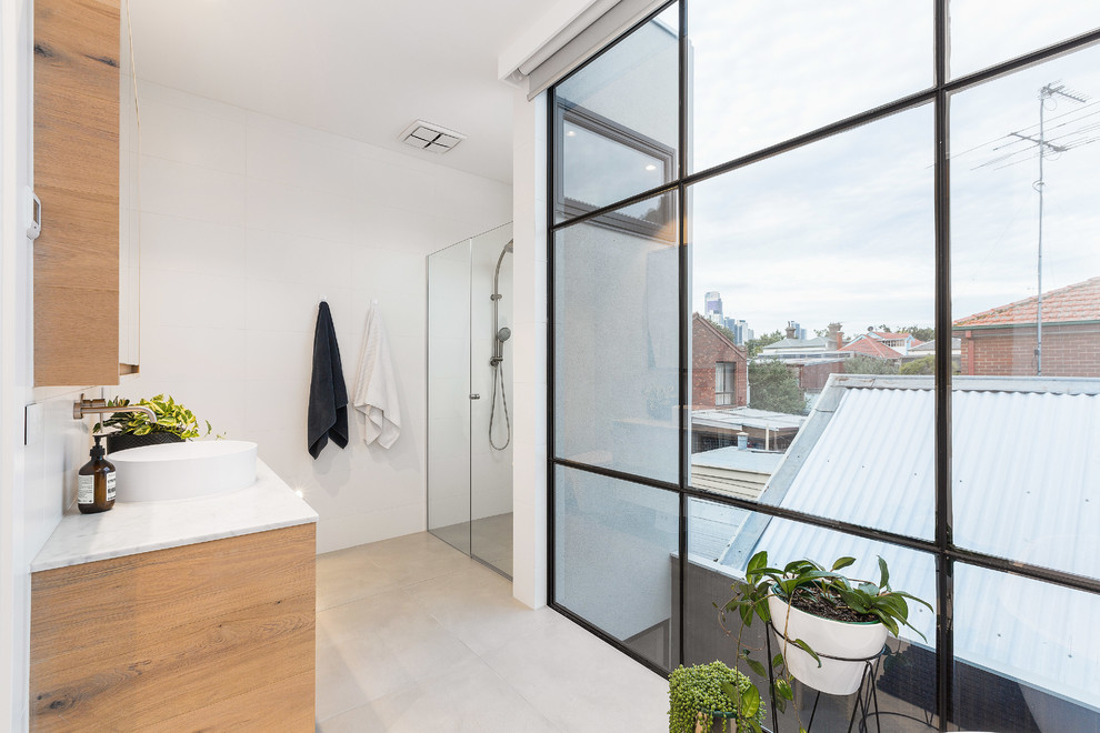 Mid-sized contemporary master wet room bathroom in Melbourne with flat-panel cabinets, white cabinets, a freestanding tub, white tile, mosaic tile, white walls, concrete floors, a vessel sink, marble benchtops, grey floor, a hinged shower door and white benchtops.
