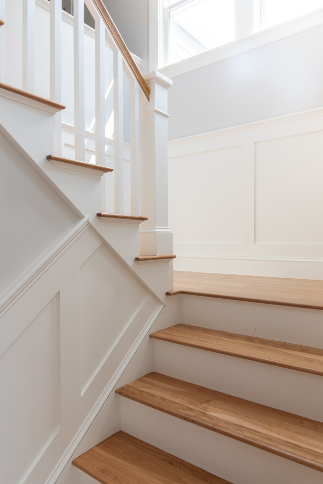 Photo of a transitional wood u-shaped staircase in Boston with wood risers and wood railing.