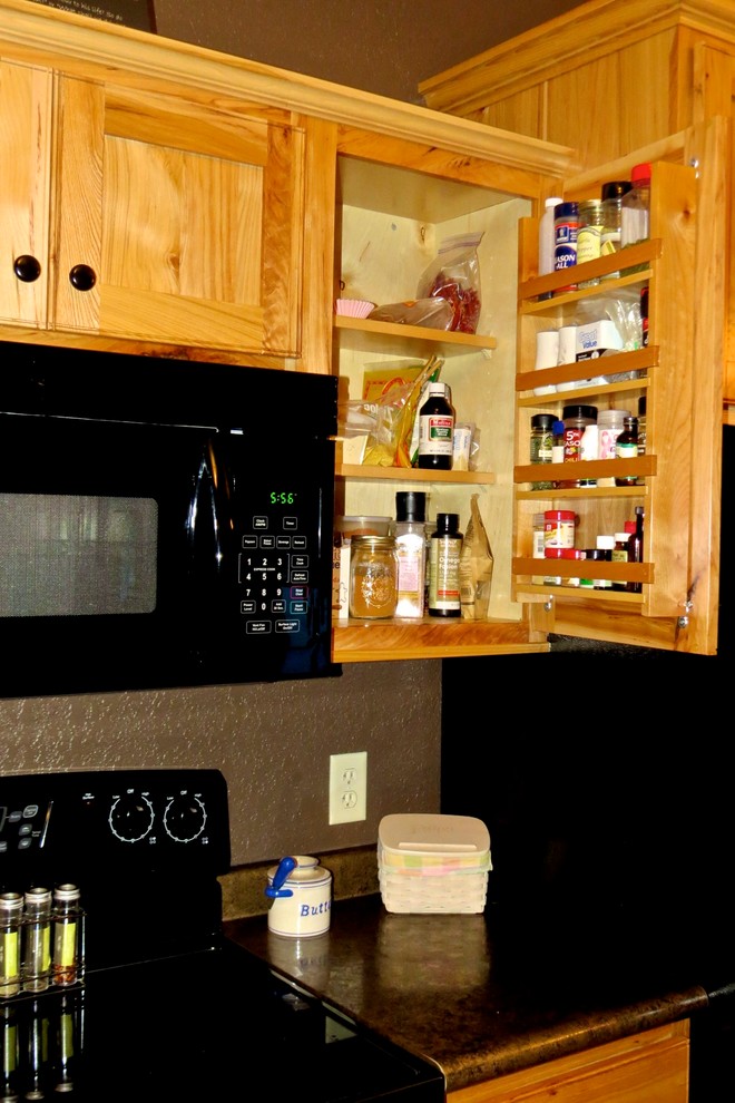 Enclosed kitchen - mid-sized rustic u-shaped medium tone wood floor and brown floor enclosed kitchen idea with a double-bowl sink, shaker cabinets, medium tone wood cabinets, black appliances and no island