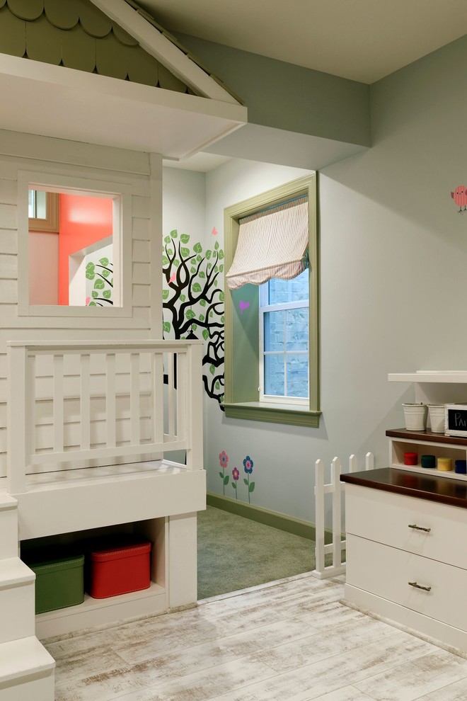 Creative and Unique Playroom - A perfect playroom space for two young girls to grow into.  The space contains a custom made playhouse, complete with hidden trap door, custom built in benches with plenty of toy storage and bench cushions for reading, lounging or play pretend.  In order to mimic an outdoor space, we added an indoor swing.  The side of the playhouse has a small soft area with green carpeting to mimic grass, and a small picket fence.  The tree wall stickers add to the theme.  A huge highlight to the space is the custom designed, custom built craft table with plenty of storage for all kinds of craft supplies.  The rustic laminate wood flooring adds to the cottage theme.
Bob Narod Photography