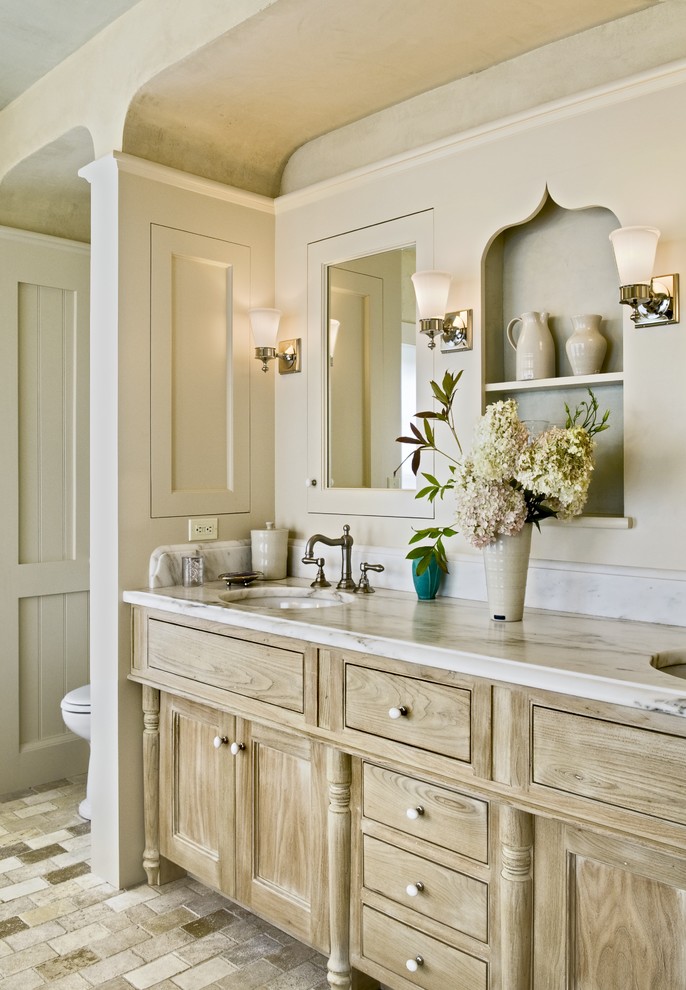 Traditional bathroom in Burlington with marble benchtops.