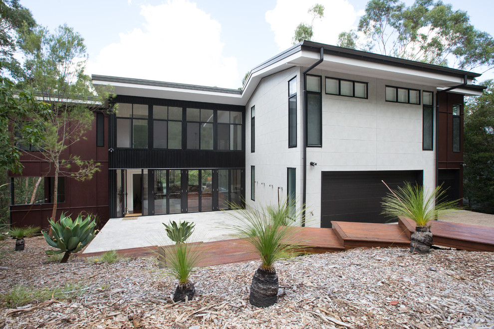 Photo of a contemporary two-storey exterior in Brisbane with mixed siding.