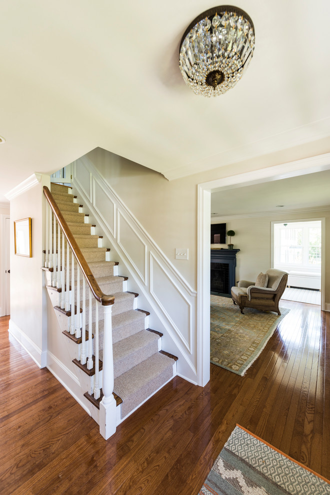 Entry hall - mid-sized transitional medium tone wood floor and brown floor entry hall idea in Philadelphia with beige walls and a black front door