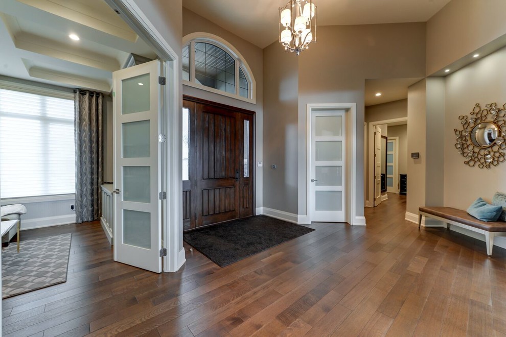 Foyer - transitional medium tone wood floor foyer idea in Edmonton with a dark wood front door and beige walls