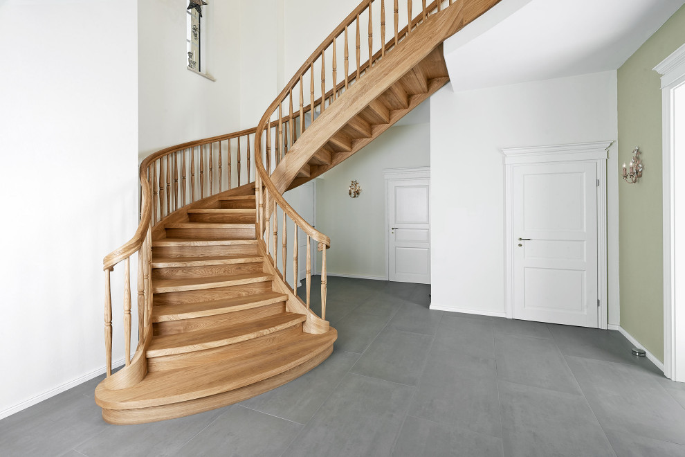 Пример оригинального дизайна: изогнутая деревянная лестница в стиле кантри с деревянными ступенями и деревянными перилами