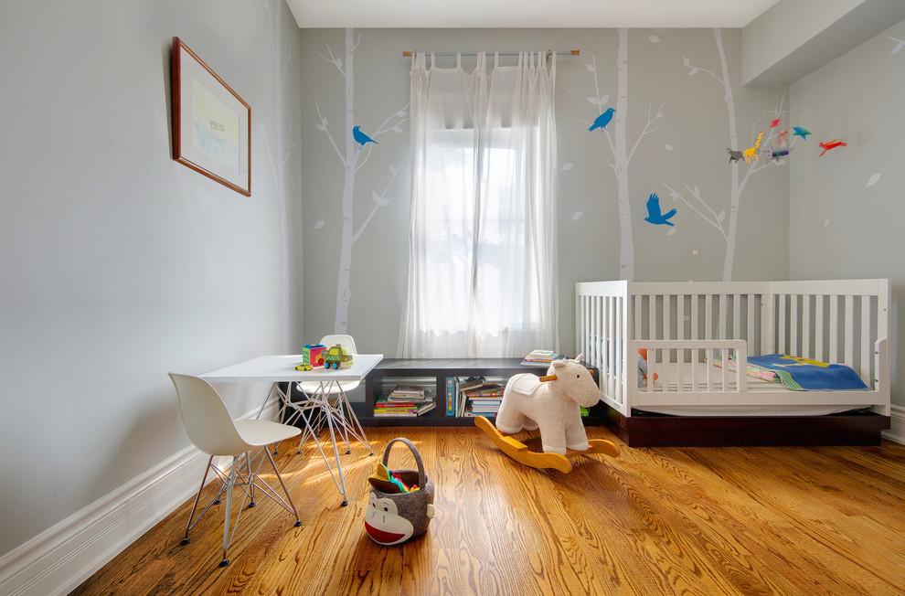 Small contemporary gender-neutral nursery in Toronto with grey walls and medium hardwood floors.