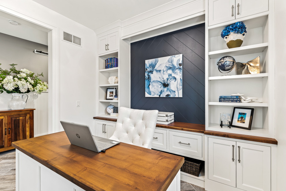 Diseño de despacho marinero de tamaño medio con paredes blancas, suelo de baldosas de porcelana, escritorio empotrado, suelo gris y machihembrado